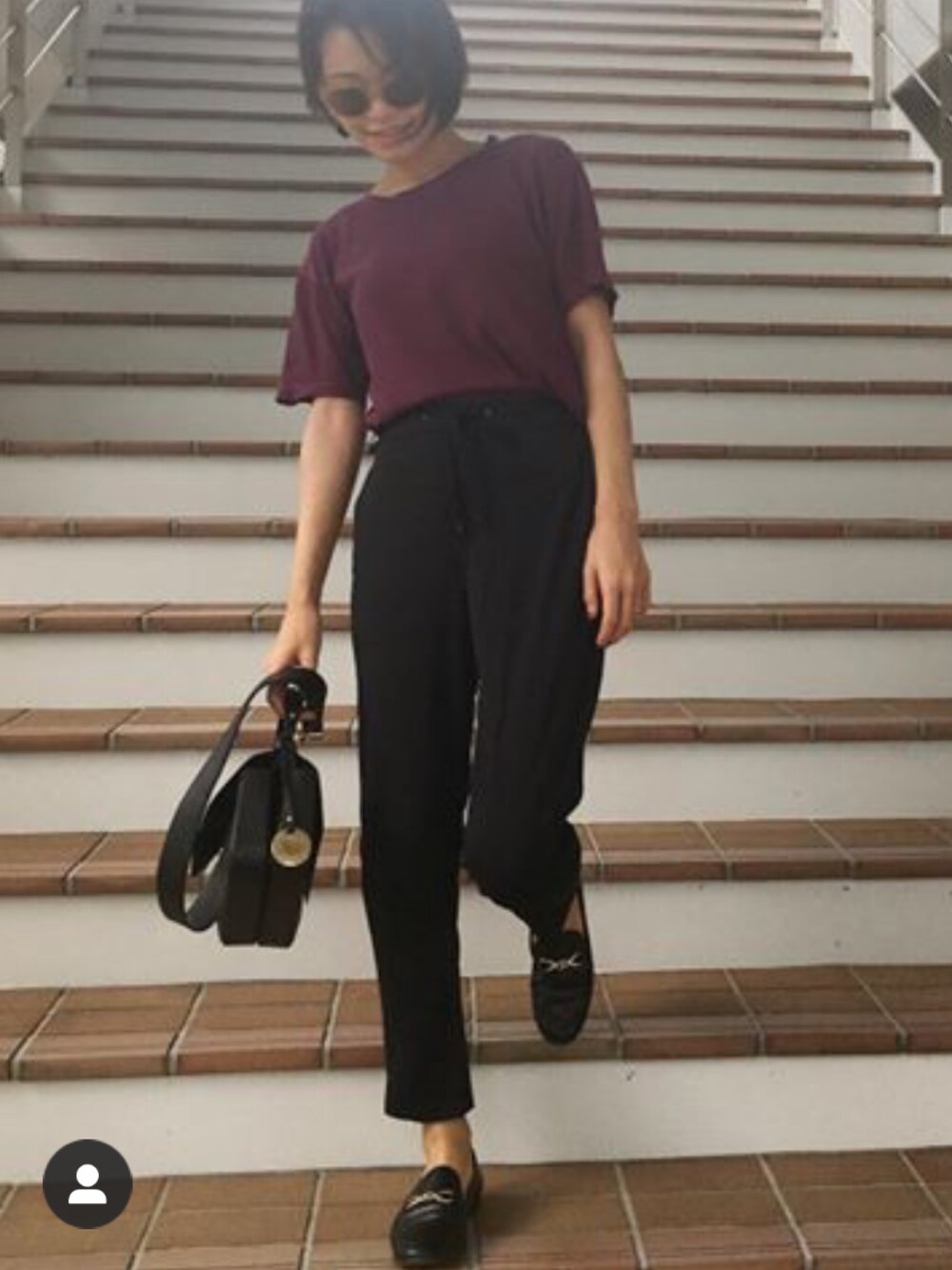 ブラック系のパンツ、ブラック系のショルダーバッグ、パープル系のTシャツ/カットソーを着用したレディースの夏コーディネートの1枚目の写真