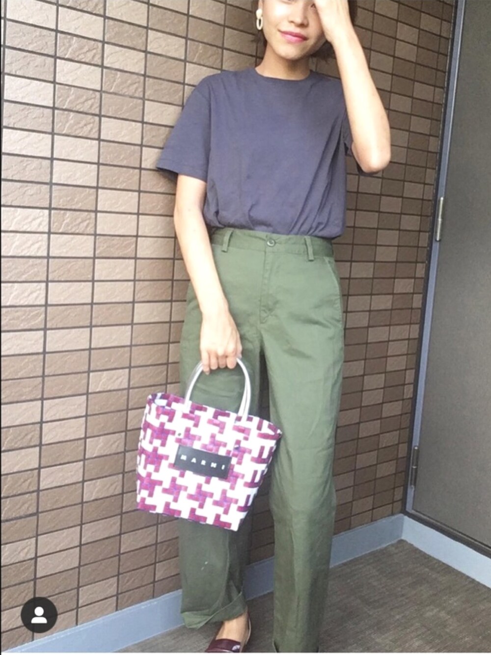 グリーン系のカーゴパンツ、レッド系のハンドバッグ、レッド系のローファーを着用したレディースの夏コーディネートの1枚目の写真