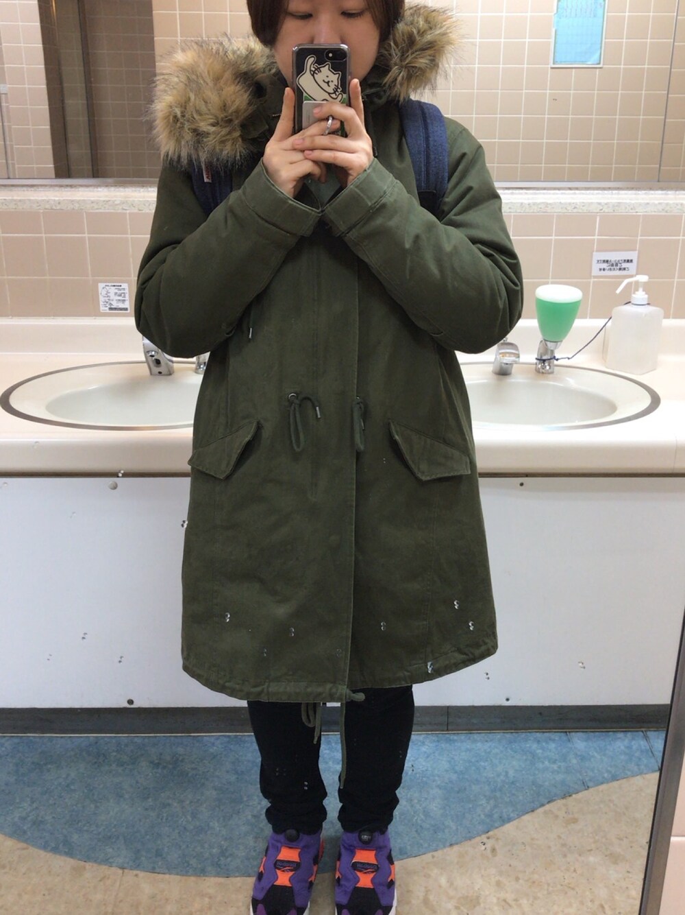 グリーン系のダウンジャケット/コート、ブラック系のその他パンツ、パープル系のスニーカーを着用したレディースの冬コーディネートの1枚目の写真