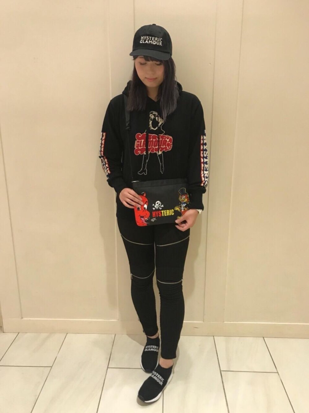 ブラック系のパーカー、ブラック系のショルダーバッグ、ブラック系のスニーカーを着用したレディースの夏コーディネートの1枚目の写真