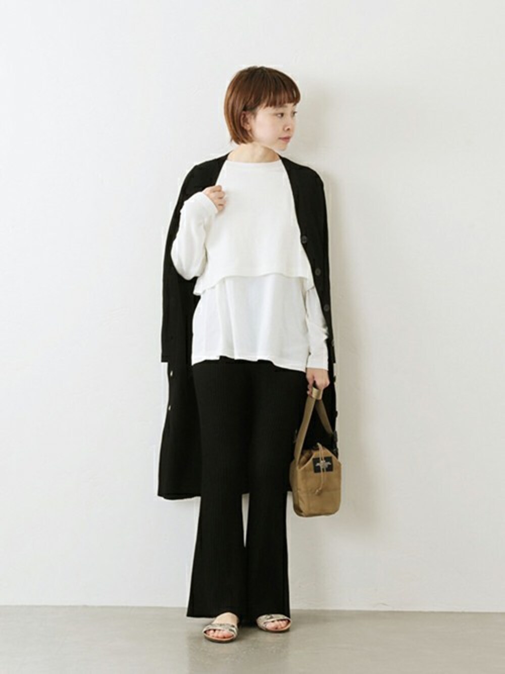 ブラック系のその他パンツ、ホワイト系のTシャツ/カットソー、ベージュ系のサンダルを着用したレディースの冬コーディネートの1枚目の写真