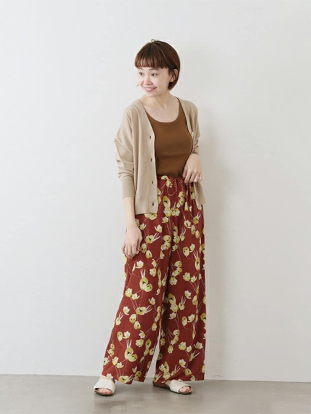 ベージュ系のカーディガン/ボレロ、ブラウン系のその他パンツ、ホワイト系のサンダルを着用したレディースの冬コーディネートの1枚目の写真