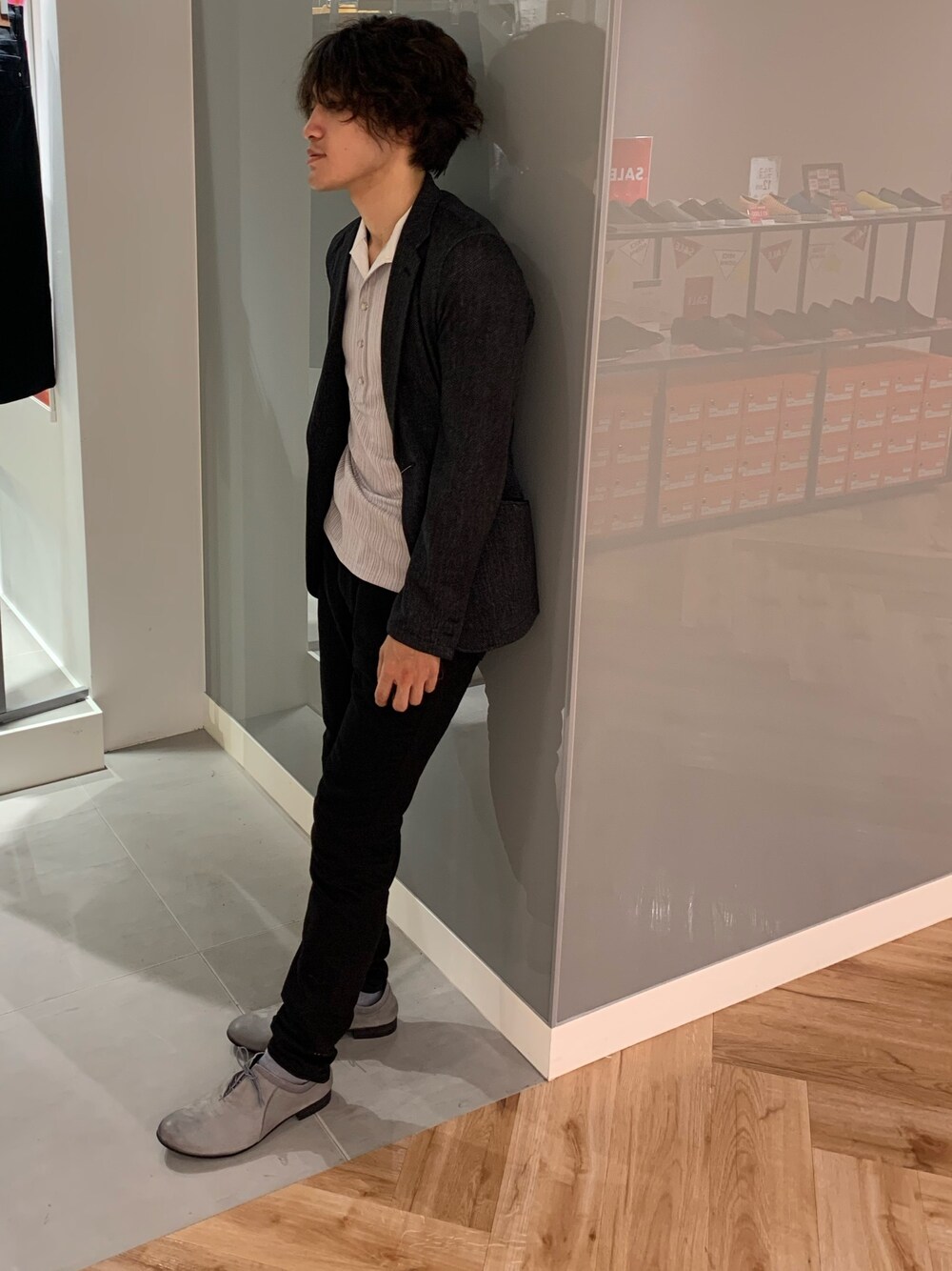 ブラック系のデニムパンツ、グレー系のドレスシューズ、グレー系のポロシャツを着用したメンズの夏コーディネートの1枚目の写真