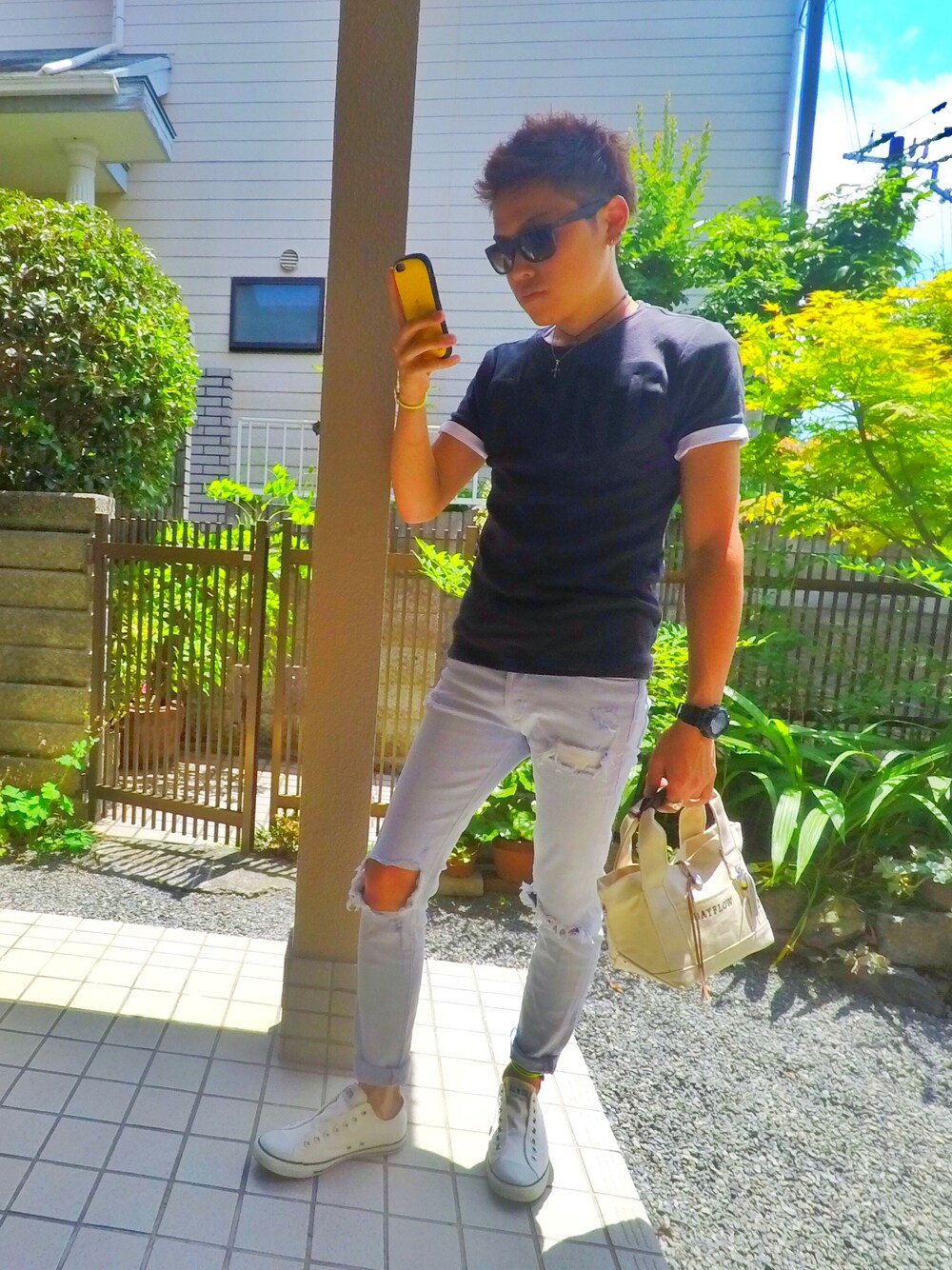 ブラック系のTシャツ/カットソー、ブルー系のデニムパンツ、ホワイト系のスリッポンを着用したメンズの夏コーディネートの1枚目の写真