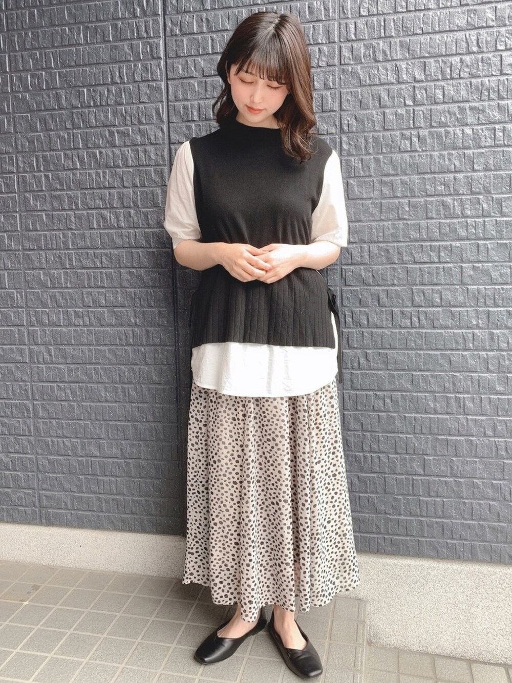 ブラック系のその他トップス、ベージュ系のスカート、ブラック系のシューズを着用したレディースの春コーディネートの1枚目の写真