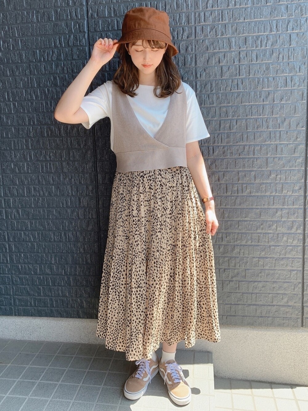 ベージュ系のスカート、ベージュ系のトップス、ベージュ系のスニーカーを着用したレディースの夏コーディネートの1枚目の写真