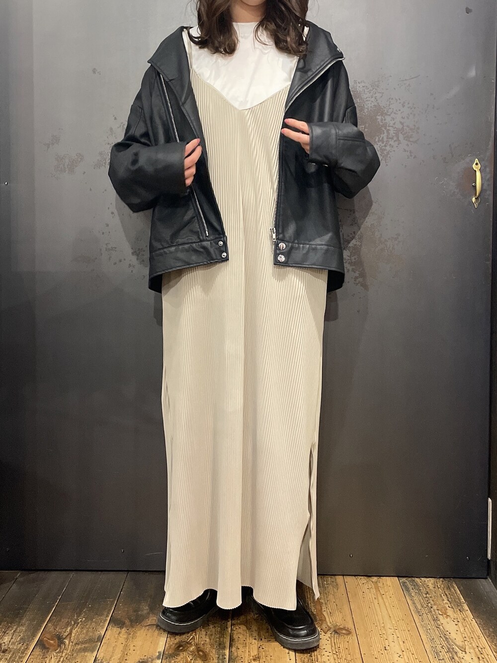 ベージュ系のワンピース/ドレス、ブラック系のライダースジャケットを着用したレディースの春コーディネートの1枚目の写真