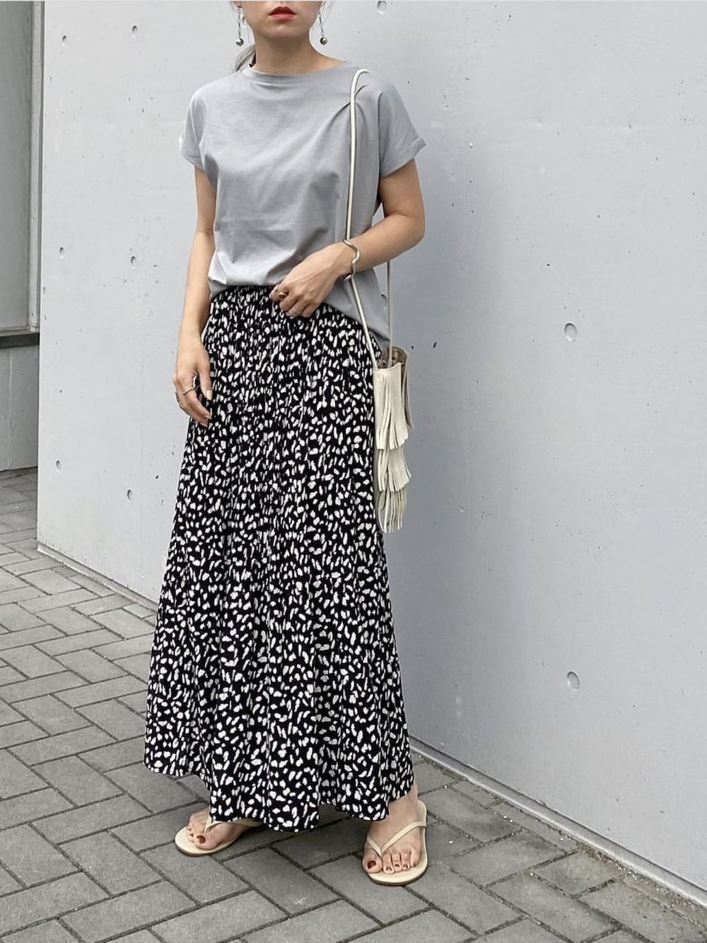グリーン系のTシャツ/カットソー、ホワイト系のショルダーバッグ、ブラック系のスカートを着用したレディースの夏コーディネートの1枚目の写真