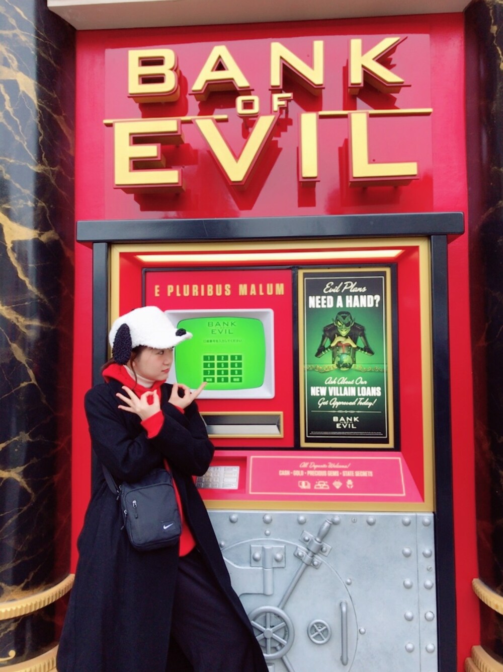 レッド系のパーカー、ブルー系のショルダーバッグ、ブラック系のジャケット/アウターを着用したレディースの冬コーディネートの1枚目の写真