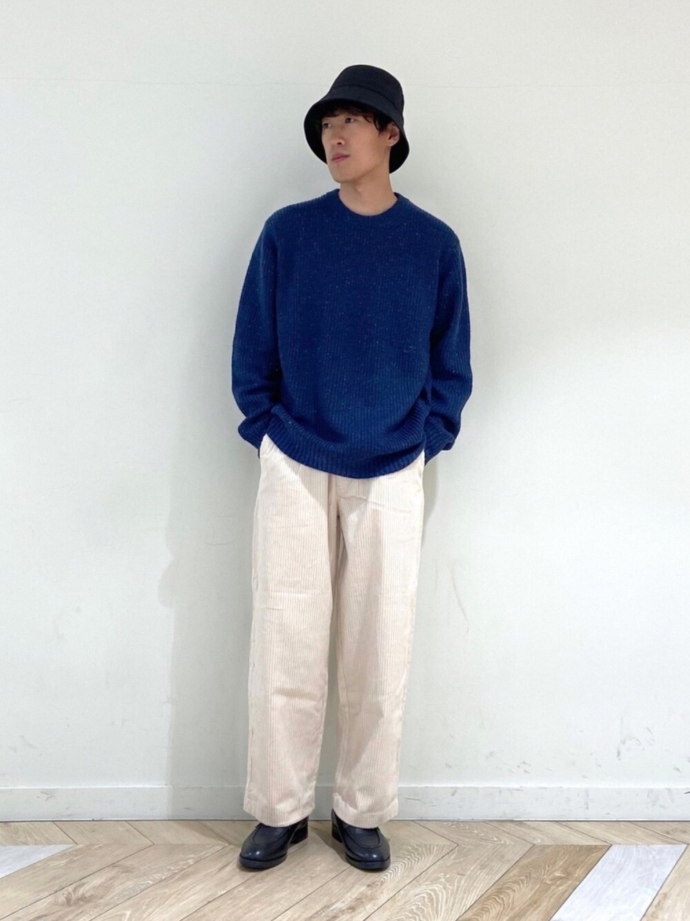 ブルー系のニット/セーター、ブラック系のローファー、ベージュ系のその他パンツを着用したメンズの秋コーディネートの1枚目の写真