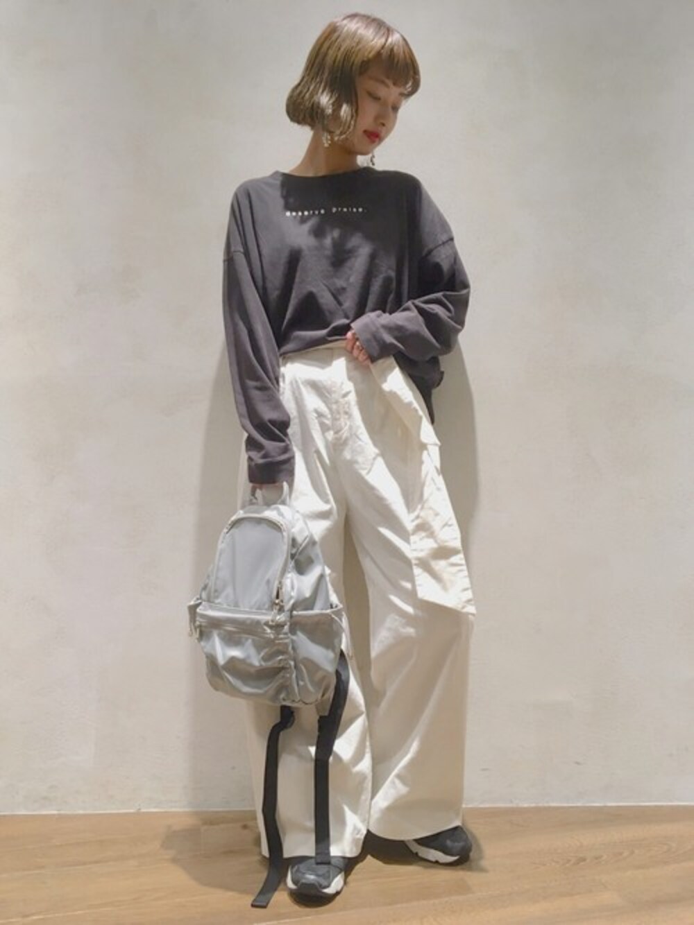 ホワイト系のその他パンツ、グレー系のバックパック/リュック、ブラック系のTシャツ/カットソーを着用したレディースの秋コーディネートの1枚目の写真