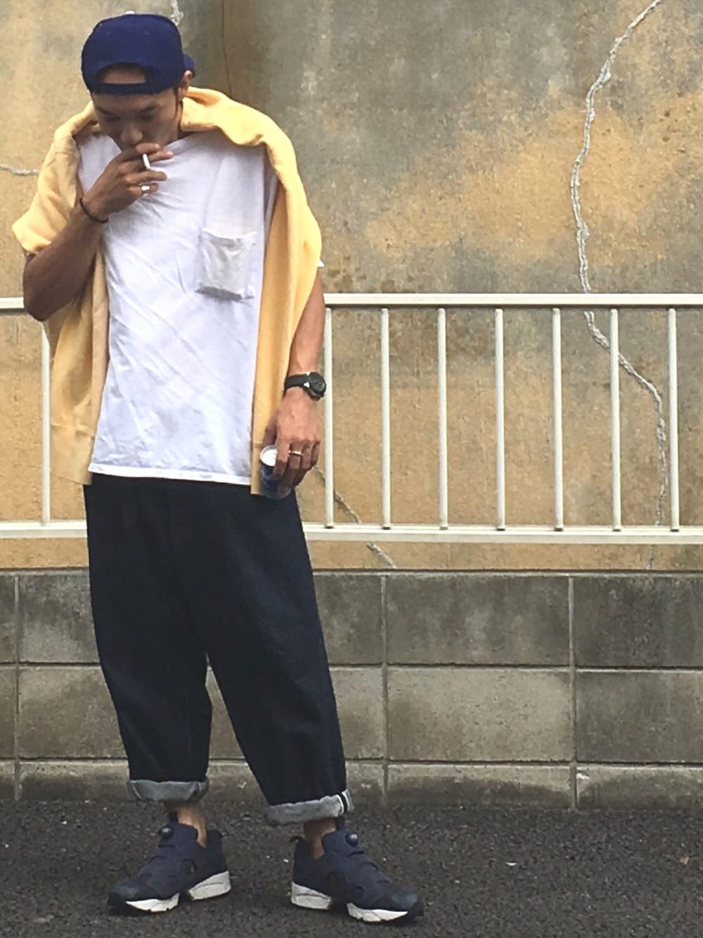 ブルー系のデニムパンツ、ホワイト系のTシャツ/カットソー、イエロー系のスウェットを着用したメンズの夏コーディネートの1枚目の写真