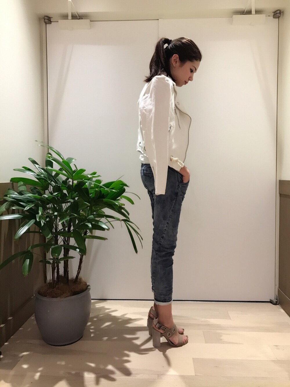 ブルー系のデニムパンツ、ベージュ系のサンダル、ホワイト系のジャケット/アウターを着用したレディースの春コーディネートの1枚目の写真