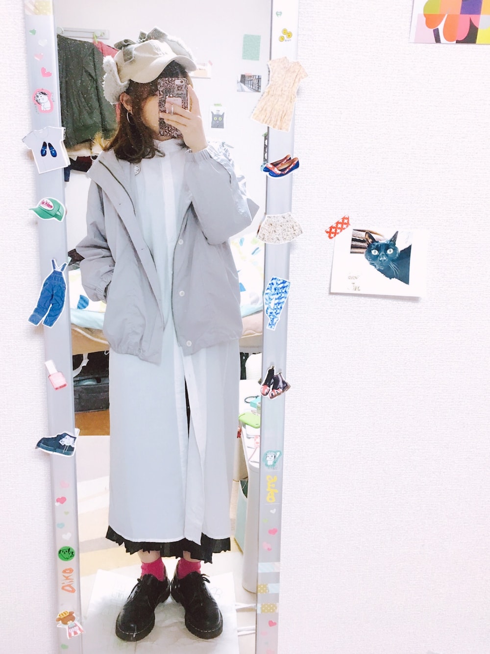 ホワイト系のシャツワンピース、ブラック系のスカート、ブラック系のブーツを着用したレディースの春コーディネートの1枚目の写真