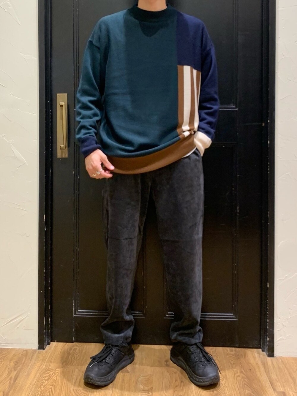 グリーン系のニット/セーター、グレー系のその他パンツ、ブラック系のスニーカーを着用したメンズの秋コーディネートの1枚目の写真