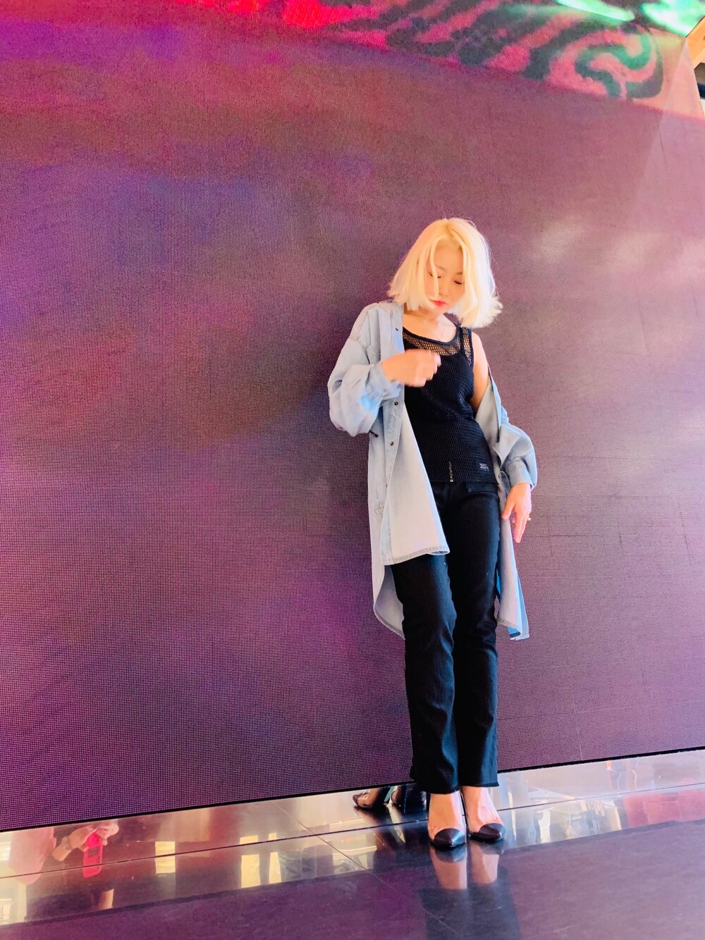 ブルー系のシャツワンピース、ブラック系のデニムパンツ、ブルー系のパンプスを着用したレディースの春コーディネートの1枚目の写真