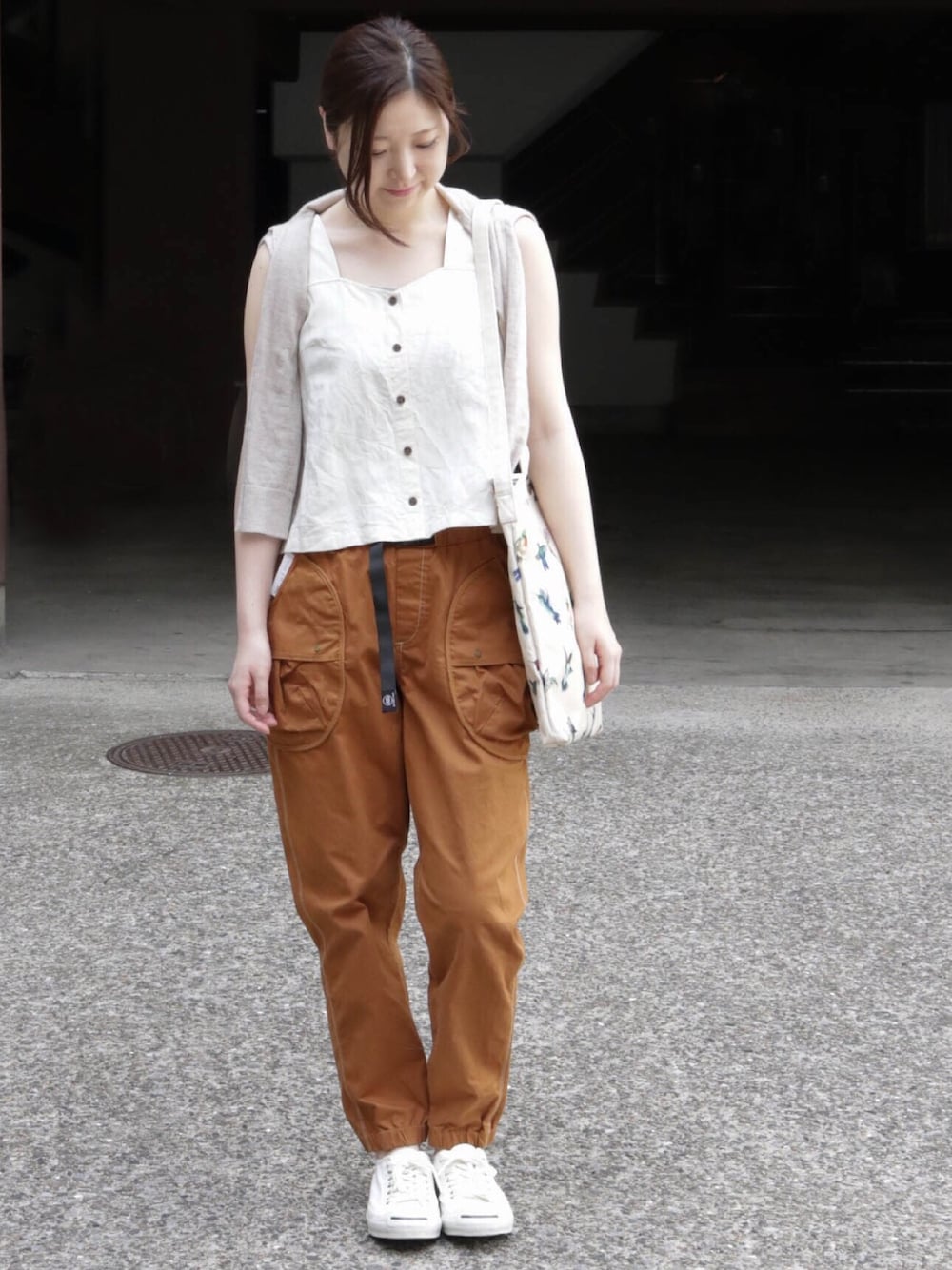 ベージュ系のタンクトップ、その他のトートバッグ、イエロー系のカーゴパンツを着用したレディースの夏コーディネートの1枚目の写真