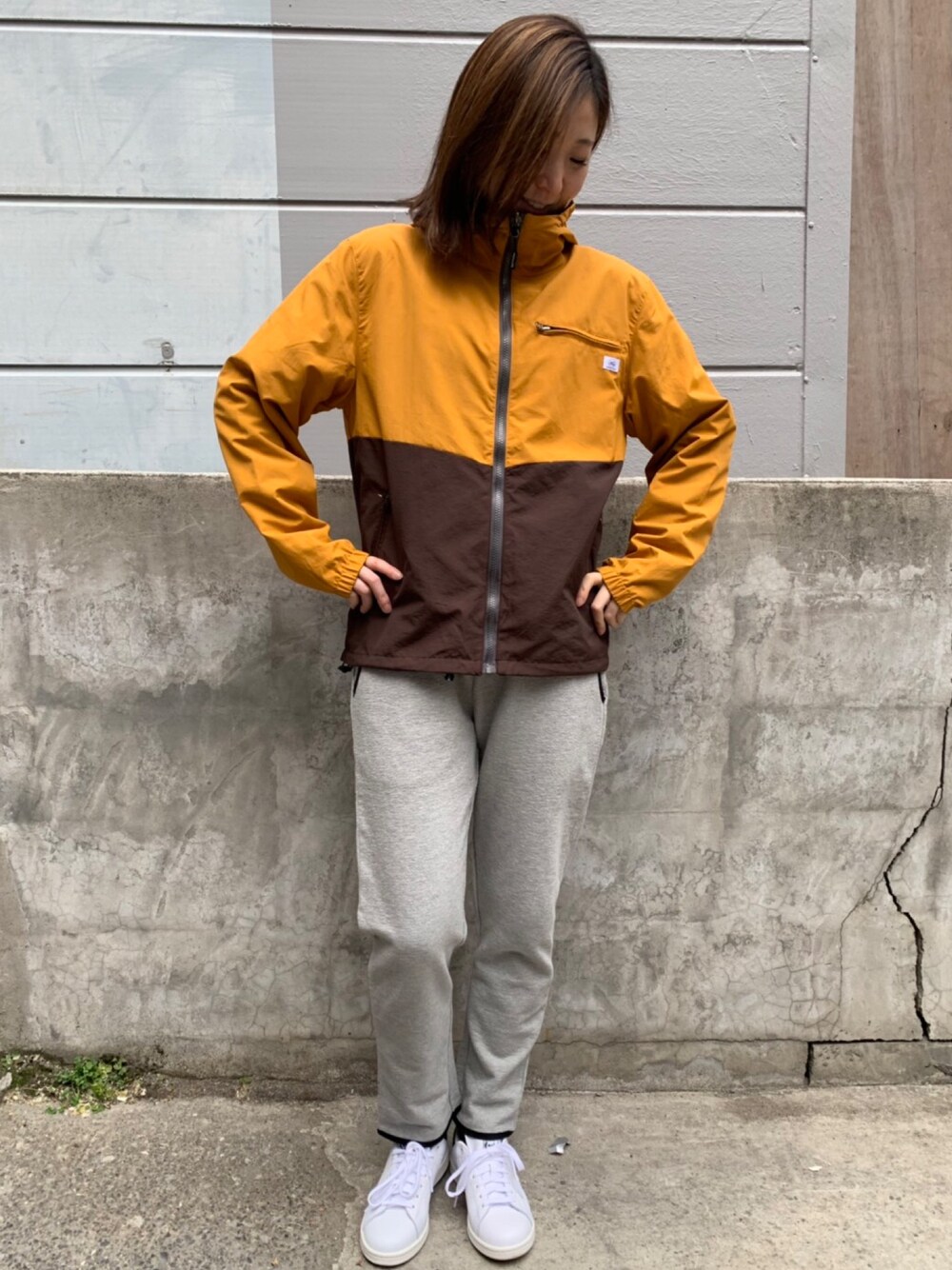 イエロー系のナイロンジャケット、グレー系のその他パンツを着用したレディースの冬コーディネートの1枚目の写真