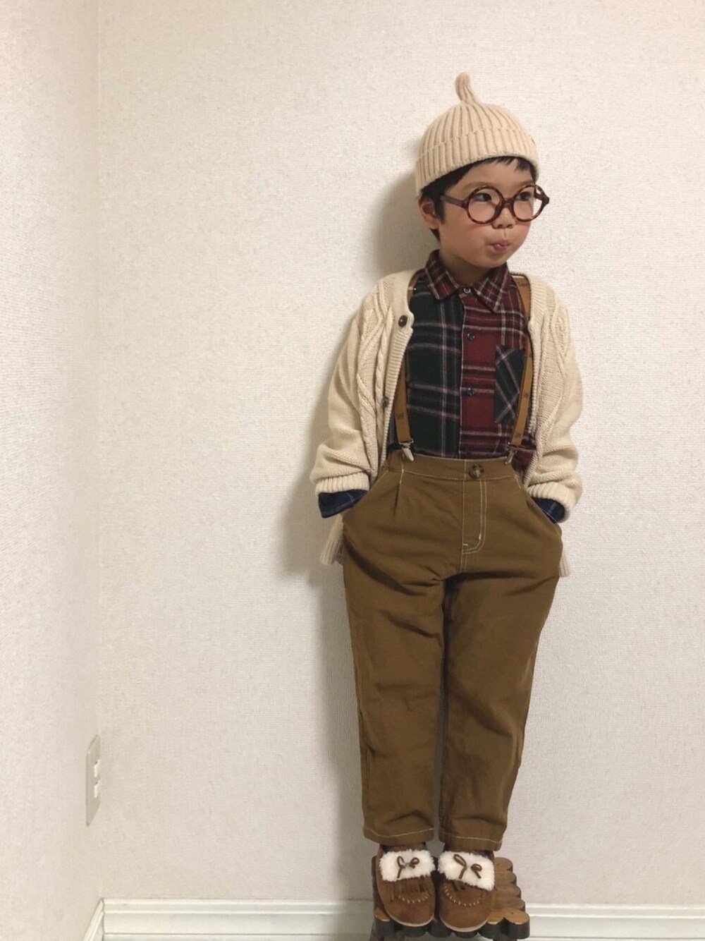 「シューラルー、キッズコーデ、プチプラ、チェックシャツ、サスペンダー、ニットカーディガン、ニット帽、モカシン、めがね、ざっくりニット」｜「SHOO・LA・RUEのこびと風折り返しニットワッチ（ニットキャップ/ビーニー、ベージュ系）」を使った、hinataさん（キッズ・110cm）の秋コーディネートの1枚目の写真