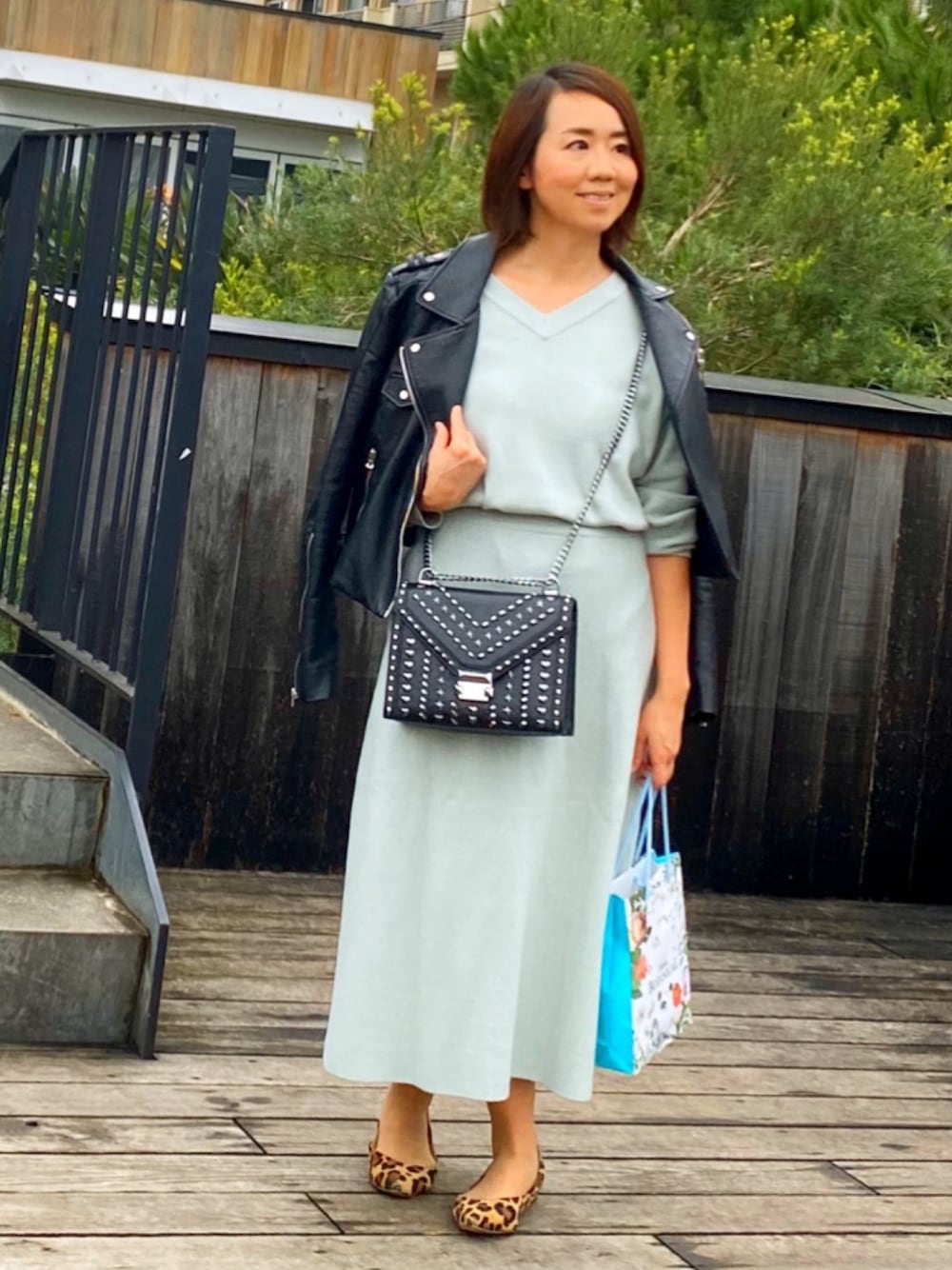 ブラック系のショルダーバッグ、その他のパンプス、ブラック系のライダースジャケットを着用したレディースの冬コーディネートの1枚目の写真