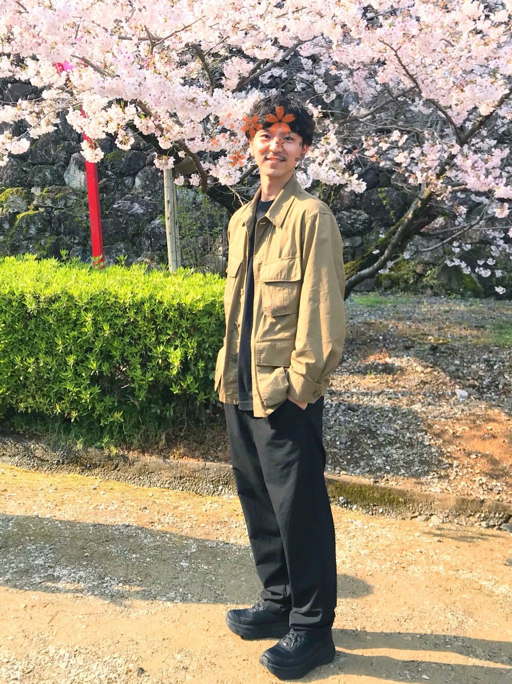 グリーン系のブルゾン、ブラック系のTシャツ/カットソー、ブラック系のスラックスを着用したメンズの春コーディネートの1枚目の写真