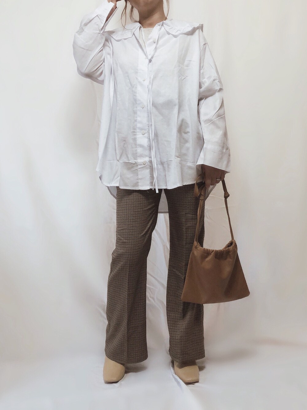 ベージュ系のパンツ、ホワイト系のシャツ/ブラウス、ベージュ系のボディバッグ/ウエストポーチを着用したレディースの秋コーディネートの1枚目の写真