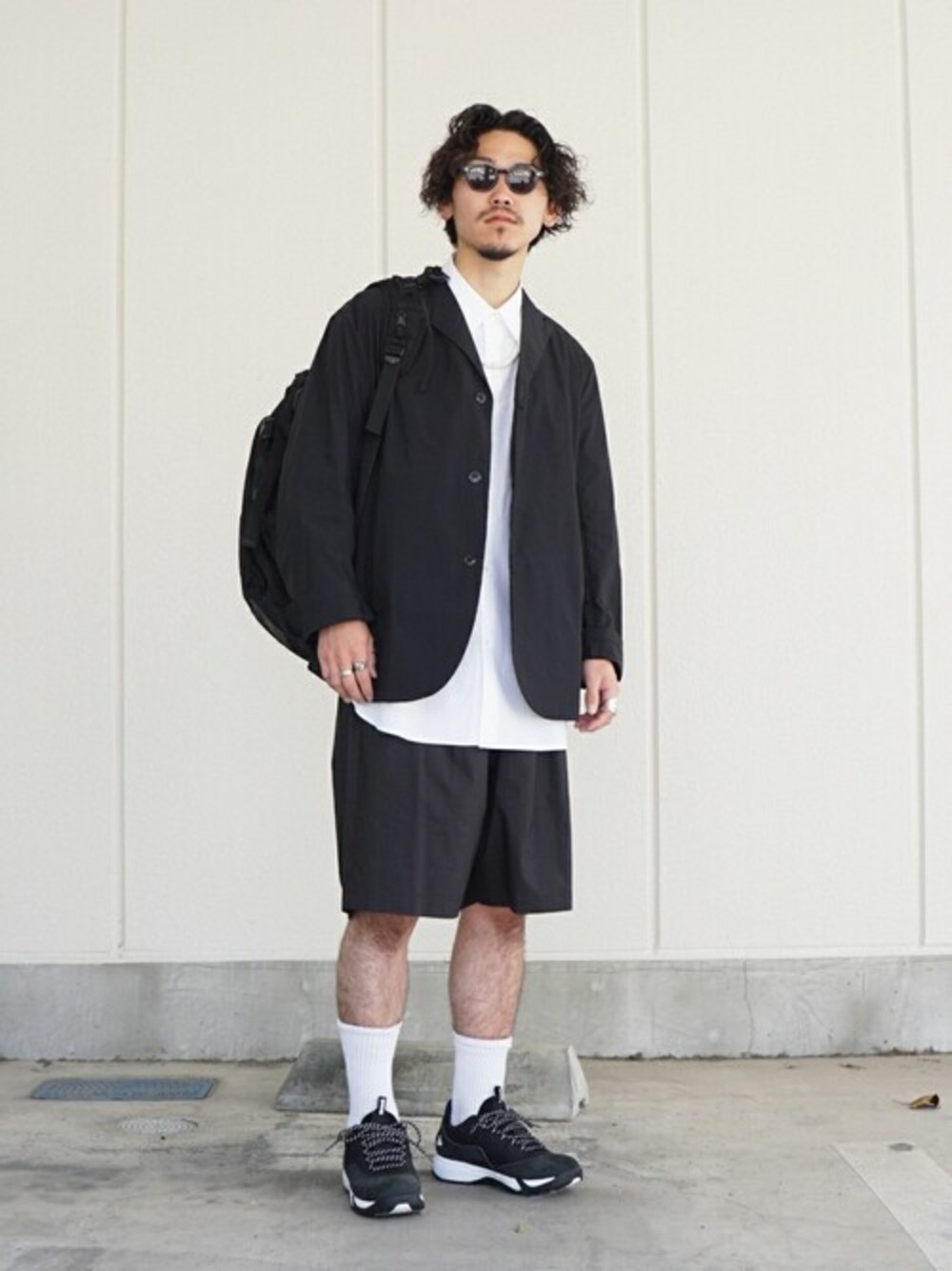 ブラック系のテーラードジャケットを着用したメンズの春コーディネートの1枚目の写真