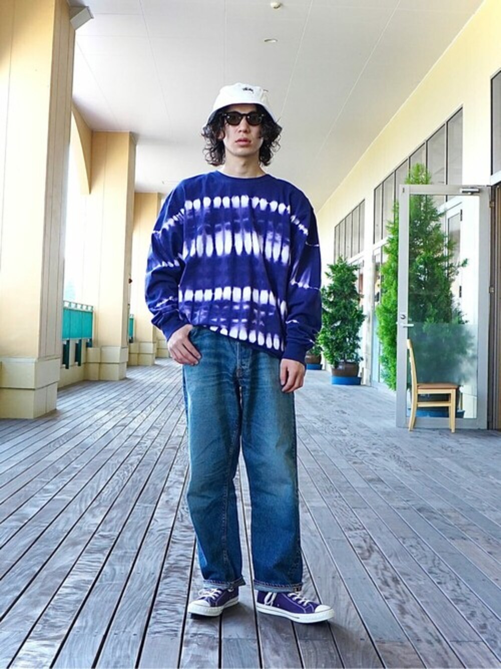 ブルー系のデニムパンツ、パープル系のTシャツ/カットソーを着用したメンズの秋コーディネートの1枚目の写真