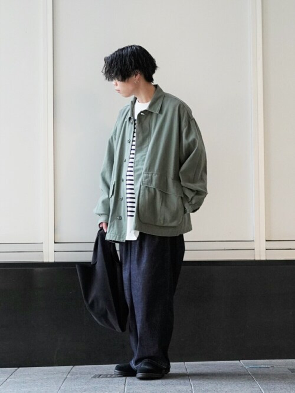 グリーン系のミリタリージャケット、ホワイト系のTシャツ/カットソー、ブルー系のデニムパンツを着用したメンズの冬コーディネートの1枚目の写真