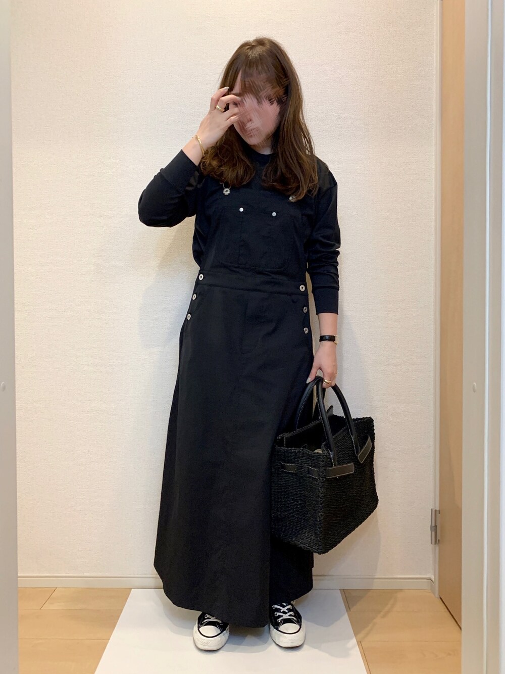 ブラック系のTシャツ/カットソー、ブラック系のジャンパースカート、ブラック系のかごバッグを着用したレディースの春コーディネートの1枚目の写真