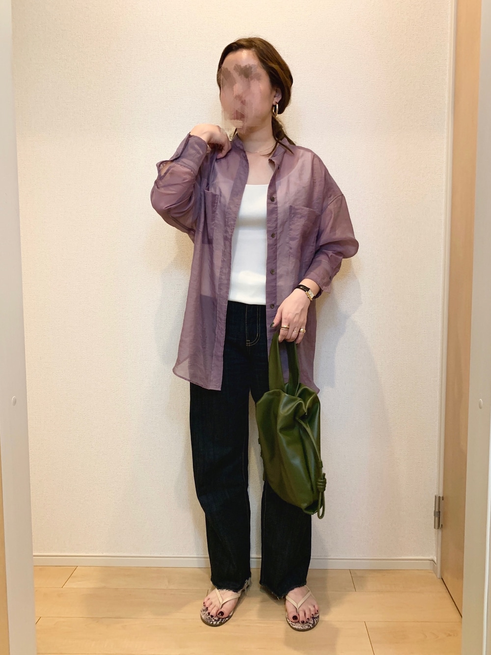 パープル系のシャツ/ブラウス、グリーン系のハンドバッグ、ブルー系のデニムパンツを着用したレディースの春コーディネートの1枚目の写真