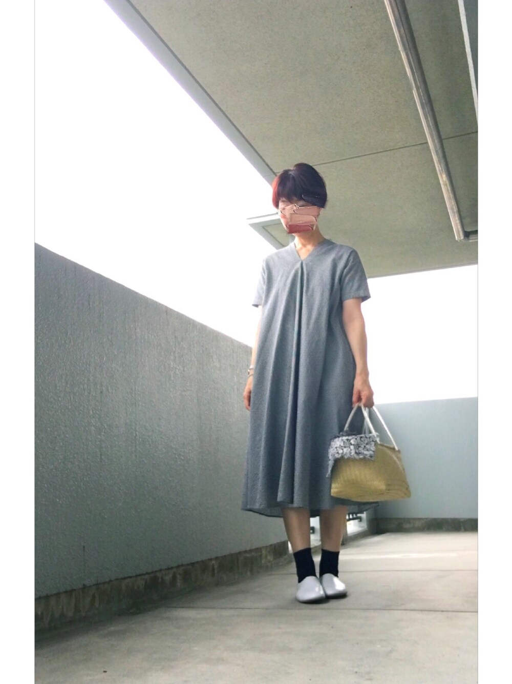 ブラック系のワンピース、ベージュ系のかごバッグ、ホワイト系のドレスシューズを着用したレディースの夏コーディネートの1枚目の写真