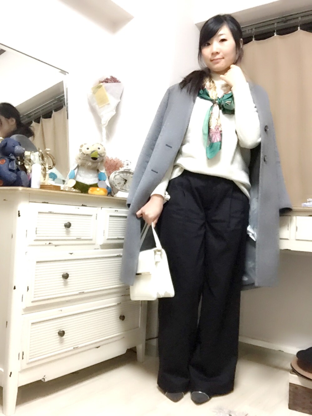 グレー系のチェスターコート、ホワイト系のニット/セーター、ブラック系のその他パンツを着用したレディースの冬コーディネートの1枚目の写真