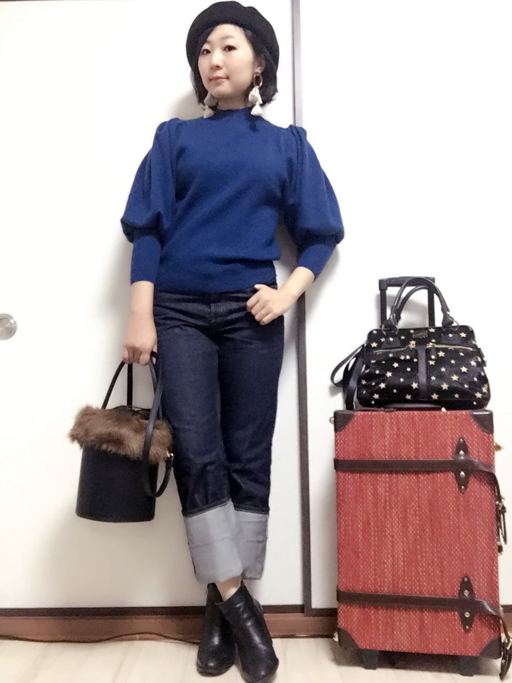 ブルー系のニット/セーター、ブルー系のデニムパンツ、ブラック系のショルダーバッグを着用したレディースの秋コーディネートの1枚目の写真