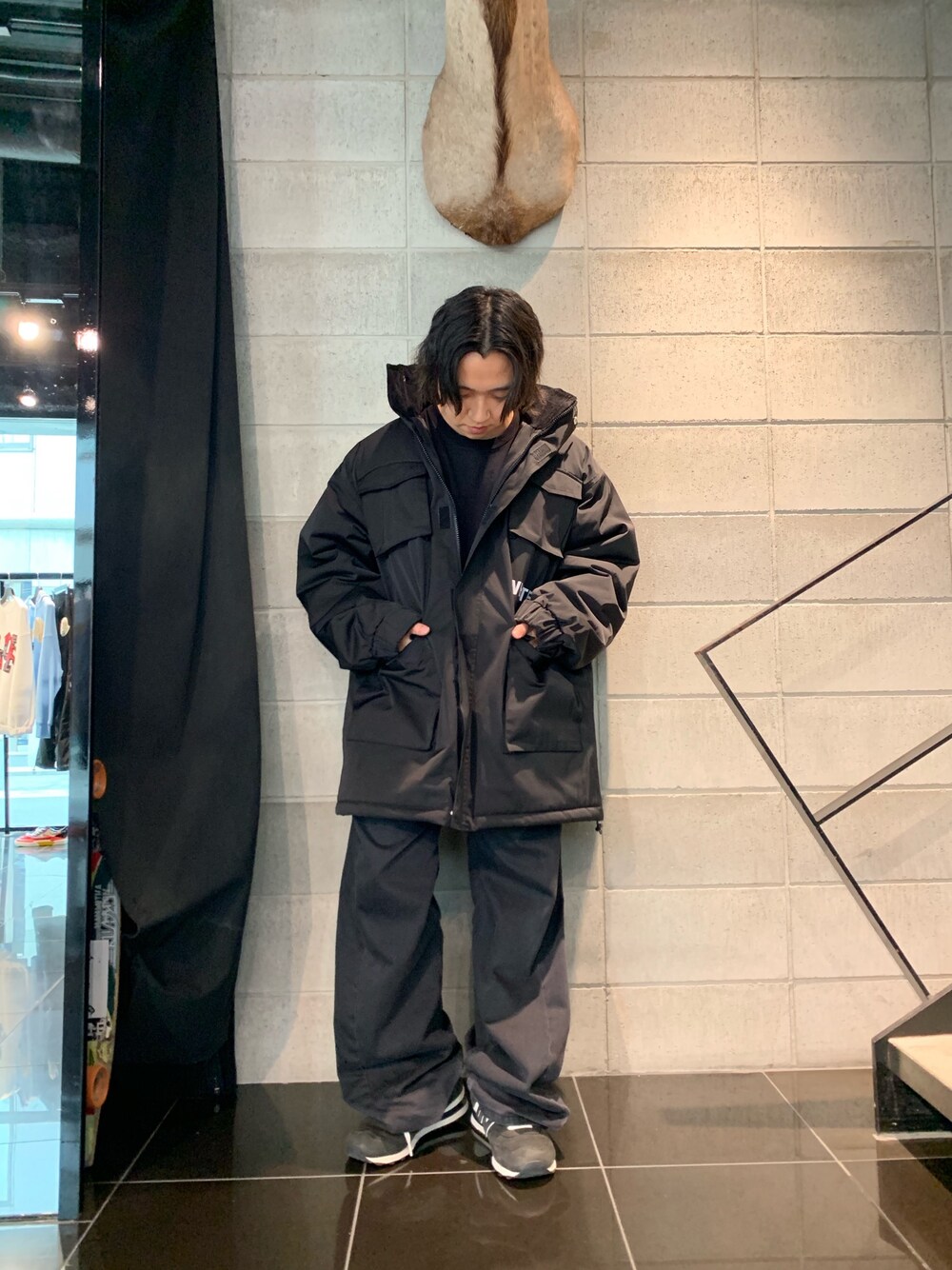 ブラック系のミリタリージャケット、ブラック系のパンツ、ブラック系のテーラードジャケットを着用したメンズの秋コーディネートの1枚目の写真