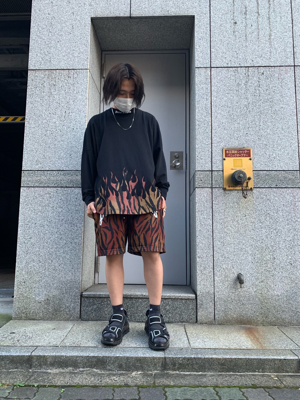 ブラック系のTシャツ/カットソー、ブラウン系のパンツ、ブラック系のスニーカーを着用したメンズの夏コーディネートの1枚目の写真