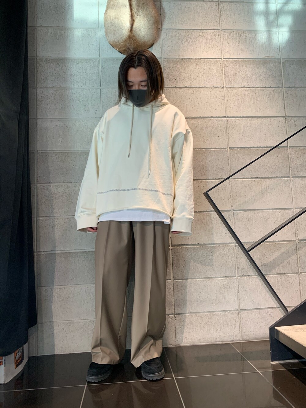 ホワイト系のパーカー、ベージュ系のスラックス、ホワイト系のパーカーを着用したメンズの冬コーディネートの1枚目の写真