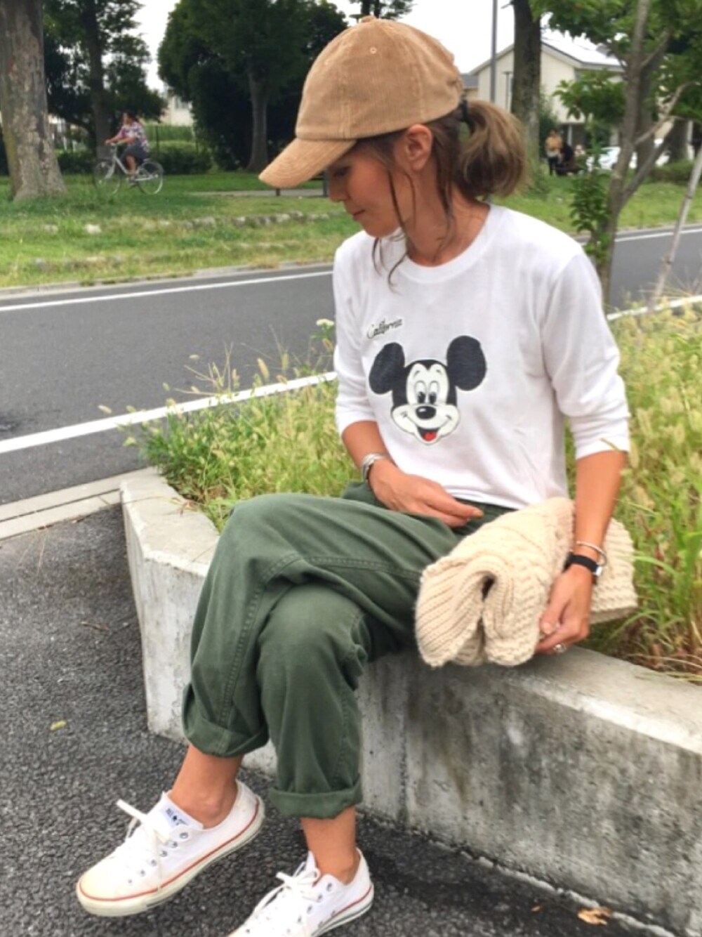 ホワイト系のTシャツ/カットソー、グリーン系のカーゴパンツ、ホワイト系のスニーカーを着用したレディースの秋コーディネートの1枚目の写真