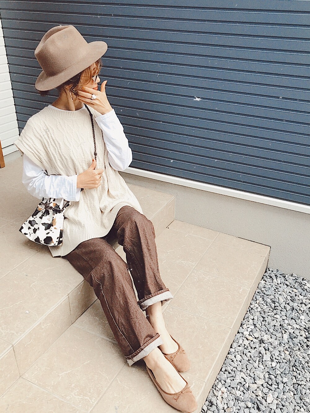 ピンク系のショルダーバッグ、ベージュ系のバレエシューズ、ベージュ系のハットを着用したレディースの秋コーディネートの1枚目の写真