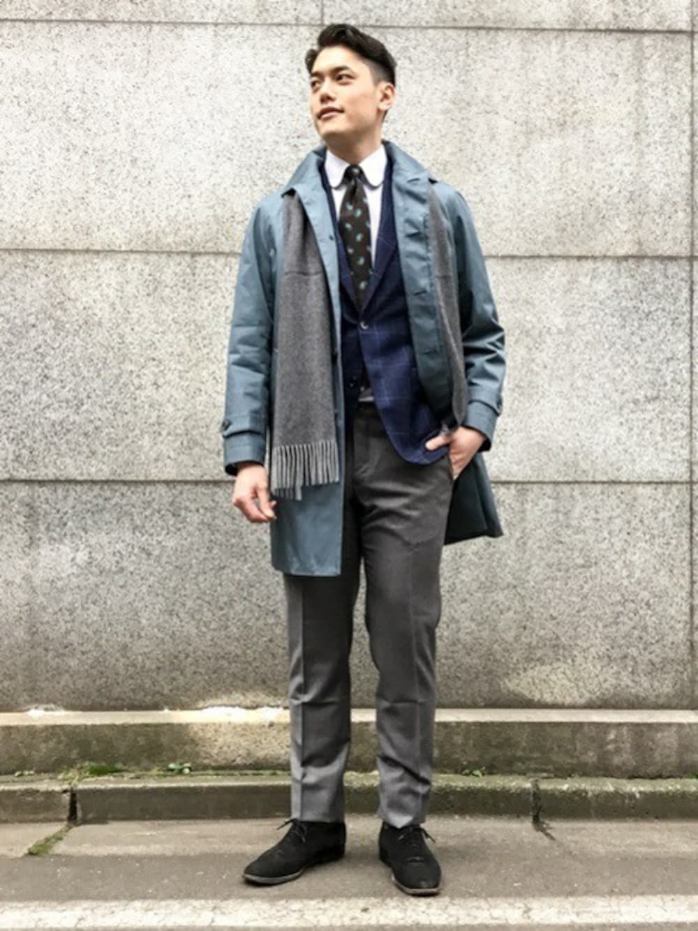 ブルー系のステンカラーコート、ブルー系のテーラードジャケット、ブラック系のドレスシューズを着用したメンズの秋コーディネートの1枚目の写真