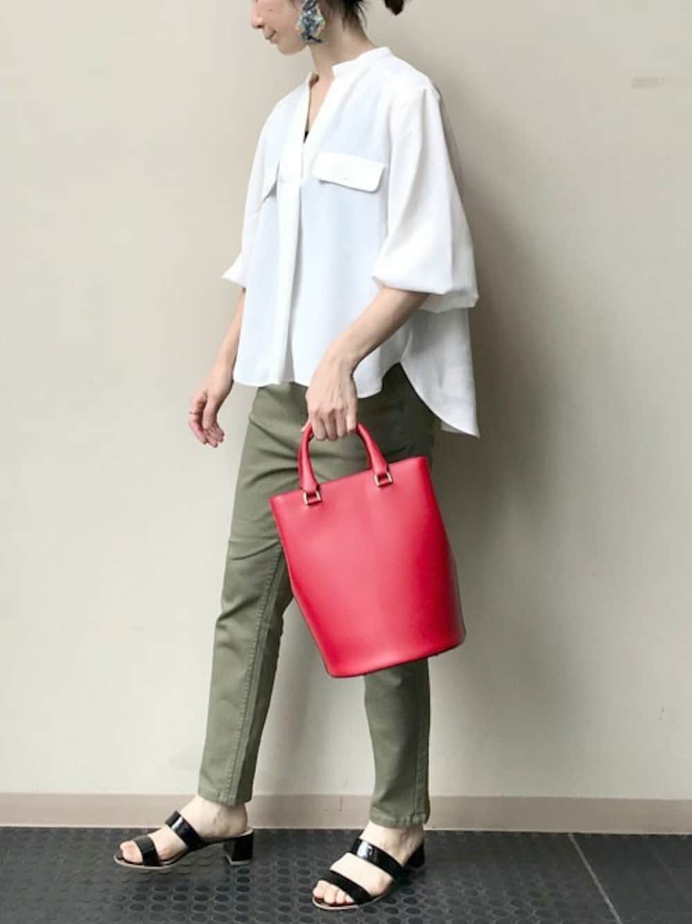 ホワイト系のシャツ/ブラウス、グリーン系のチノパンツ、レッド系のショルダーバッグを着用したレディースの春コーディネートの1枚目の写真