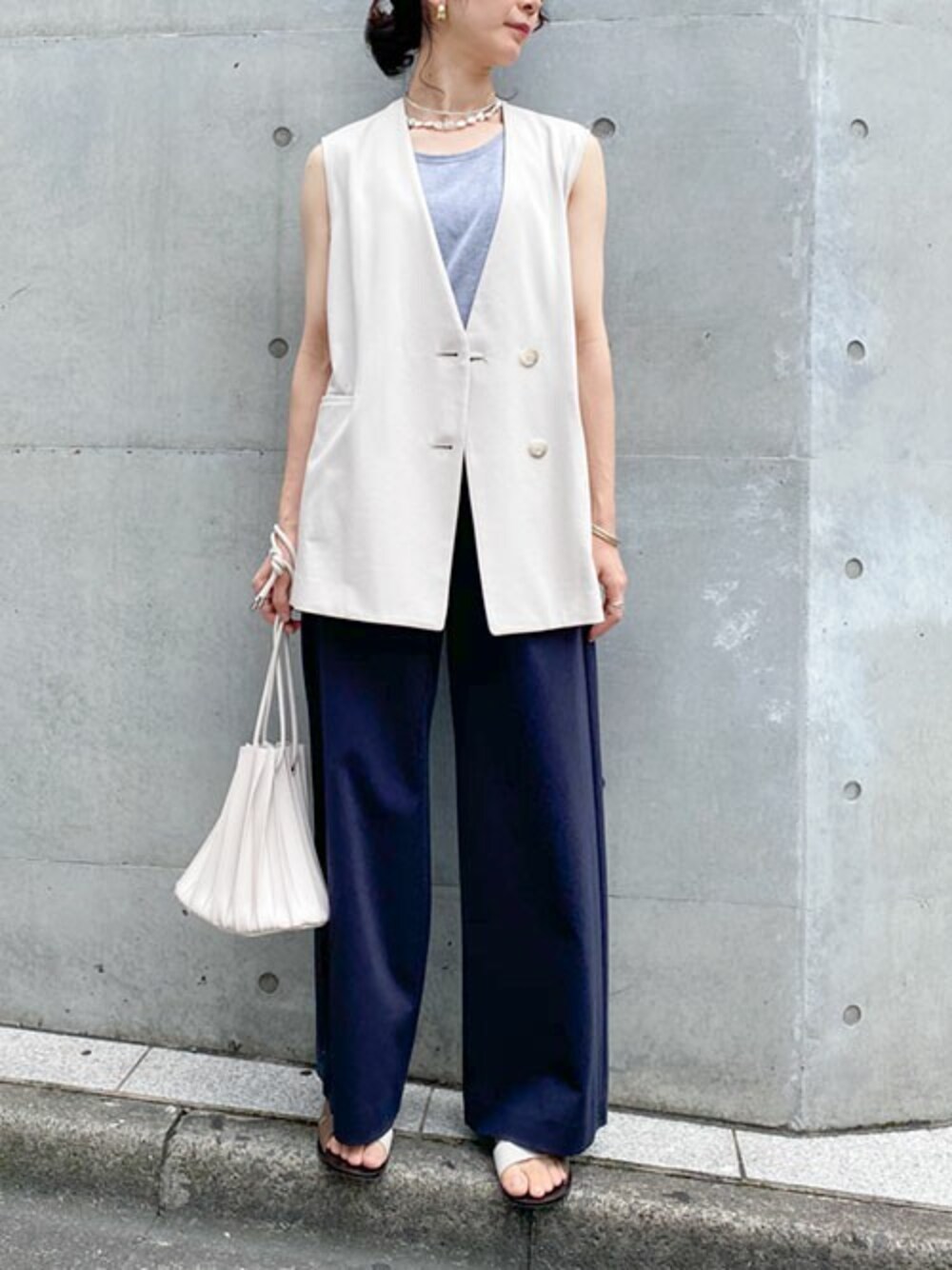 ベージュ系のベスト、グレー系のタンクトップ、ブルー系のその他パンツを着用したレディースの夏コーディネートの1枚目の写真