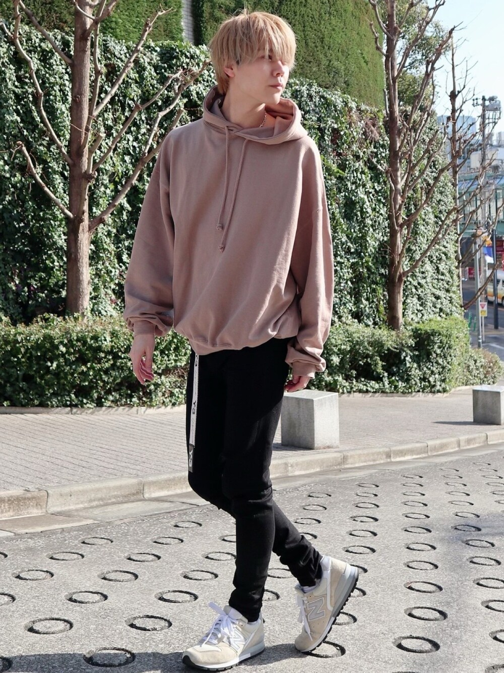 ベージュ系のパーカー、ブラック系のデニムパンツ、ベージュ系のスニーカーを着用したメンズの春コーディネートの1枚目の写真