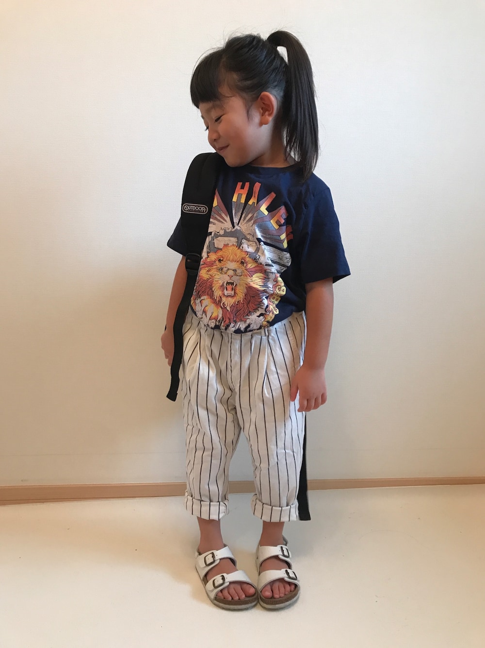 ホワイト系のその他パンツ、ホワイト系のサンダル、ブラック系のバックパック/リュックを着用したキッズの秋コーディネートの1枚目の写真