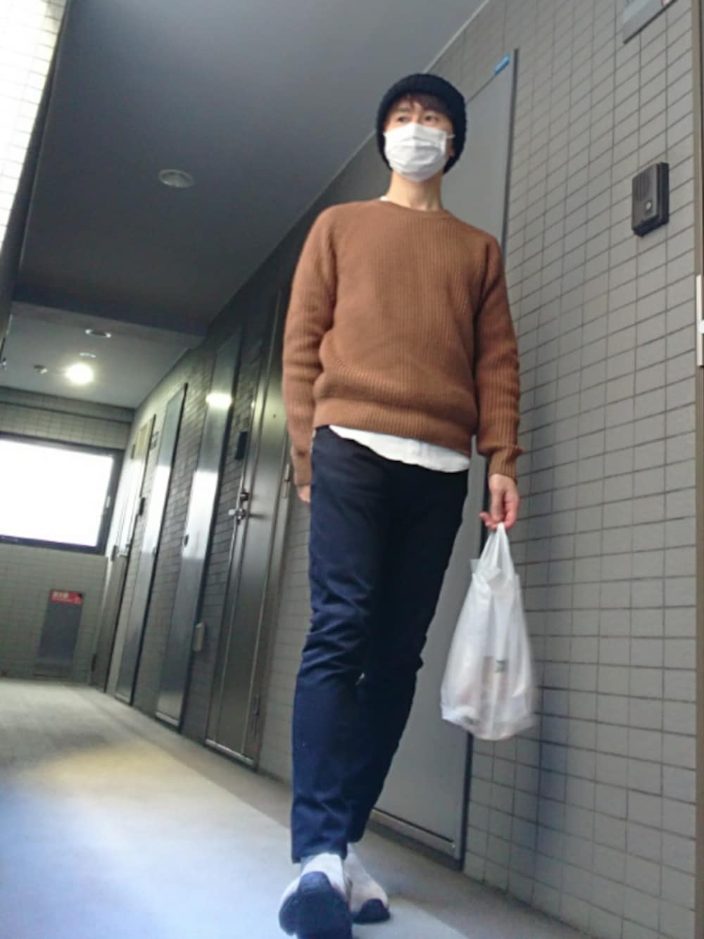 ホワイト系のTシャツ/カットソー、ブラック系のその他パンツ、ベージュ系のニット/セーターを着用したメンズの冬コーディネートの1枚目の写真