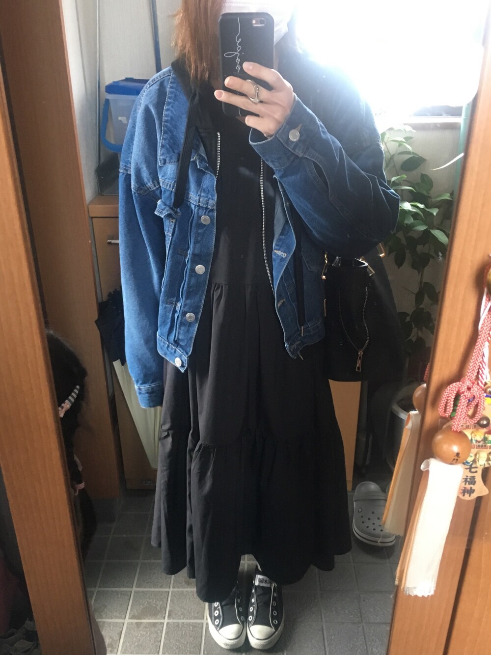 ブラック系のワンピース/ドレス、ブルー系のデニムジャケット、ブラック系のショルダーバッグを着用したレディースの春コーディネートの1枚目の写真