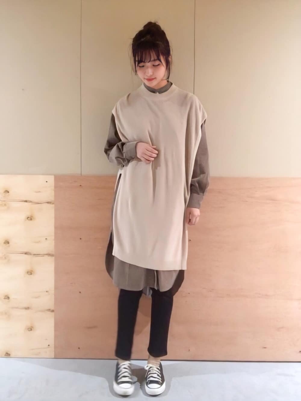 ベージュ系のベスト、ブラウン系のワンピース、ブラック系のその他パンツを着用したレディースの秋コーディネートの1枚目の写真