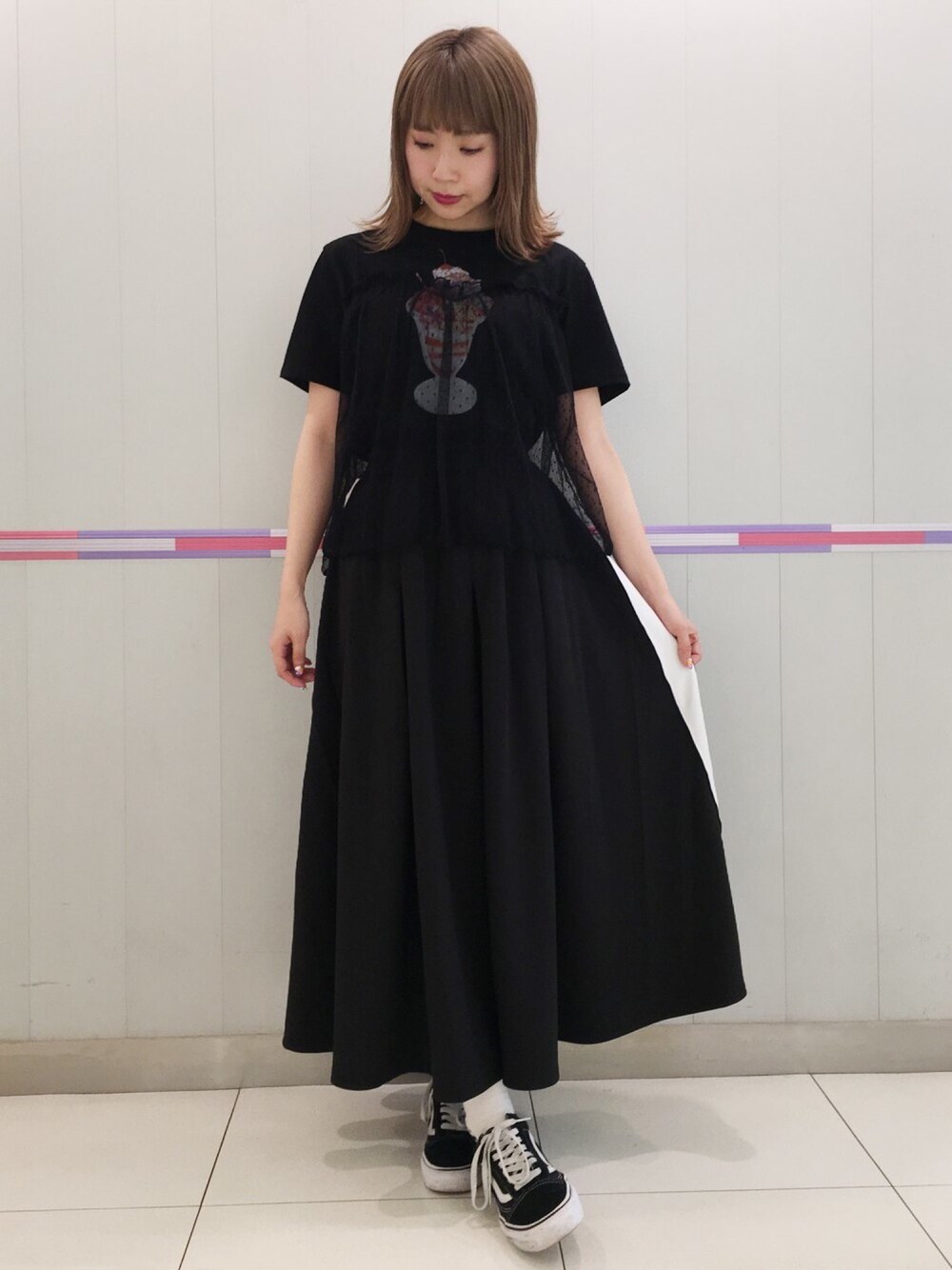 ブラック系のTシャツ/カットソー、ブラック系のスカート、ブラック系のスニーカーを着用したレディースの春コーディネートの1枚目の写真