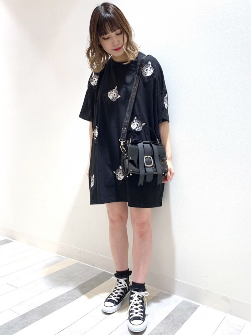 ブラック系のTシャツ/カットソー、ブラック系のショルダーバッグ、ブラック系のスニーカーを着用したレディースの春コーディネートの1枚目の写真