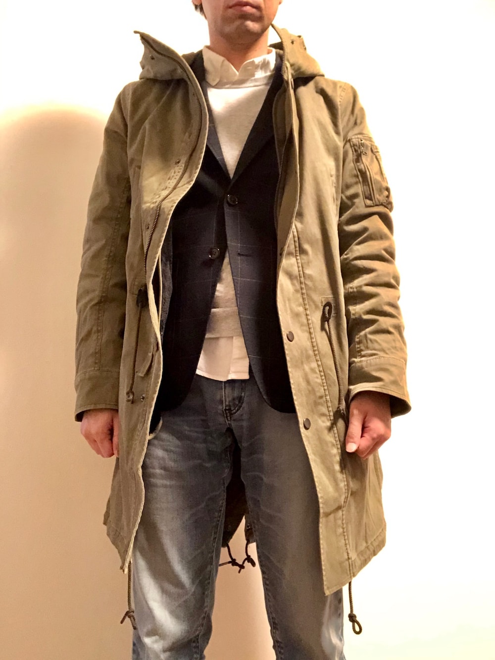 ホワイト系のシャツ/ブラウス、グレー系のニット/セーター、グリーン系のモッズコートを着用したメンズの春コーディネートの1枚目の写真